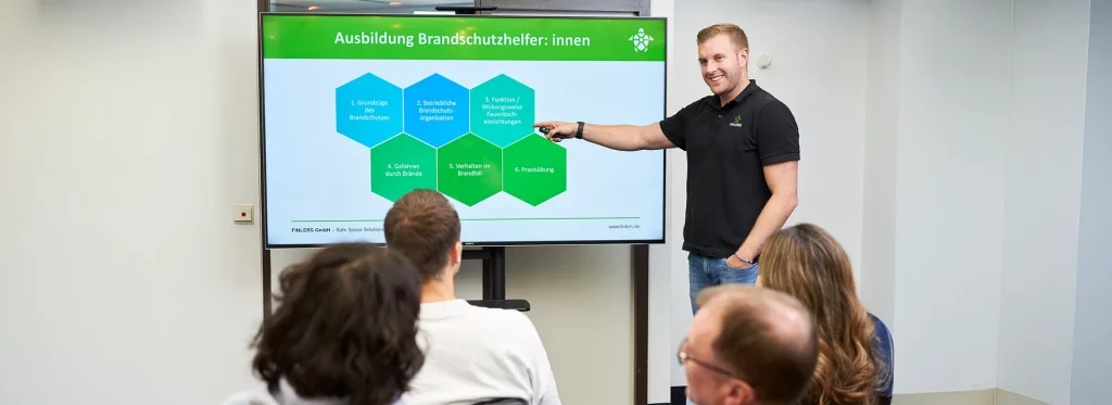Mitarbeiter Stefan Randi hält eine Schulung über Brandschutzhelfer:innen.
