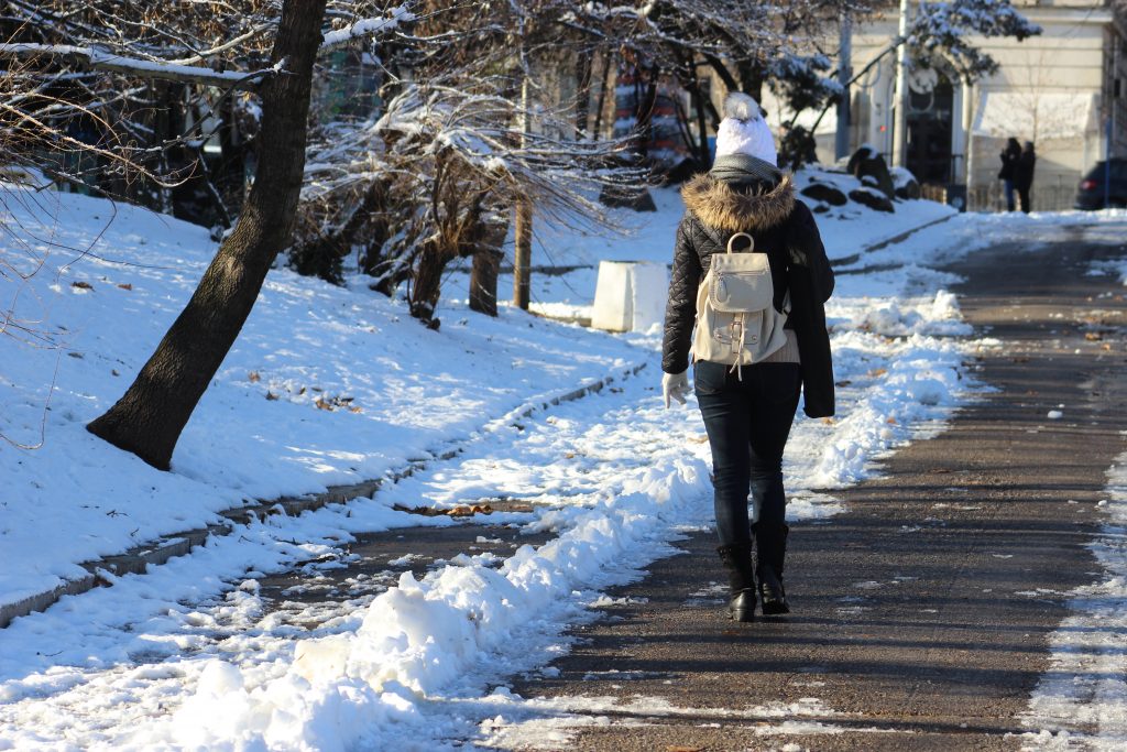 rear view woman walking snow covered road winter