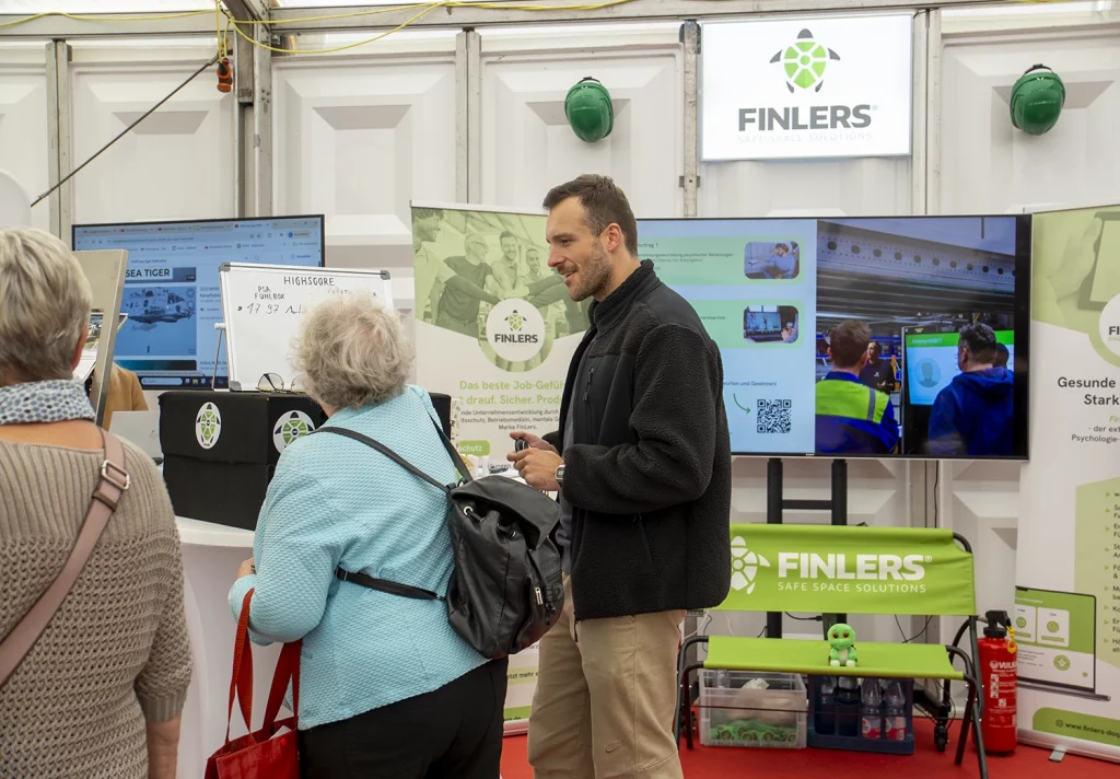 Finlers-Mitarbeiter im Gespräch mit Besuchern am Messestand auf der Donauries-Ausstellung in Donauwörth.
