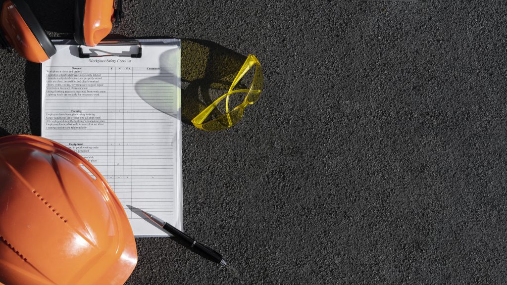 Equipment eines Sicherheits- und Gesundheitsschutzkoordinators liegt auf dem Boden.